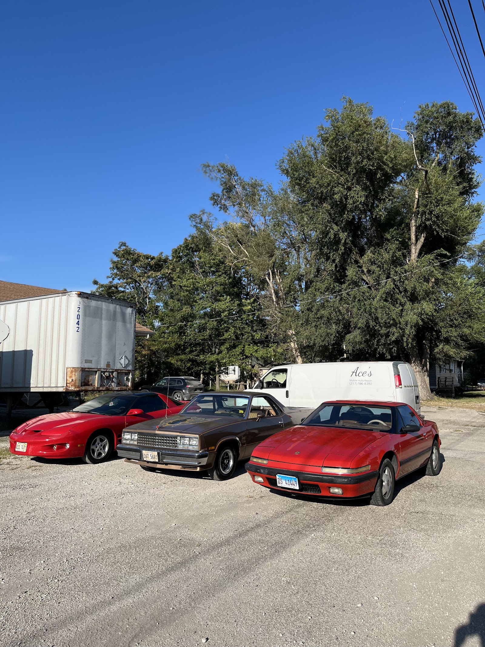 Three classic cars parked on gravel with Ace's Mobile Auto Repair van in the background