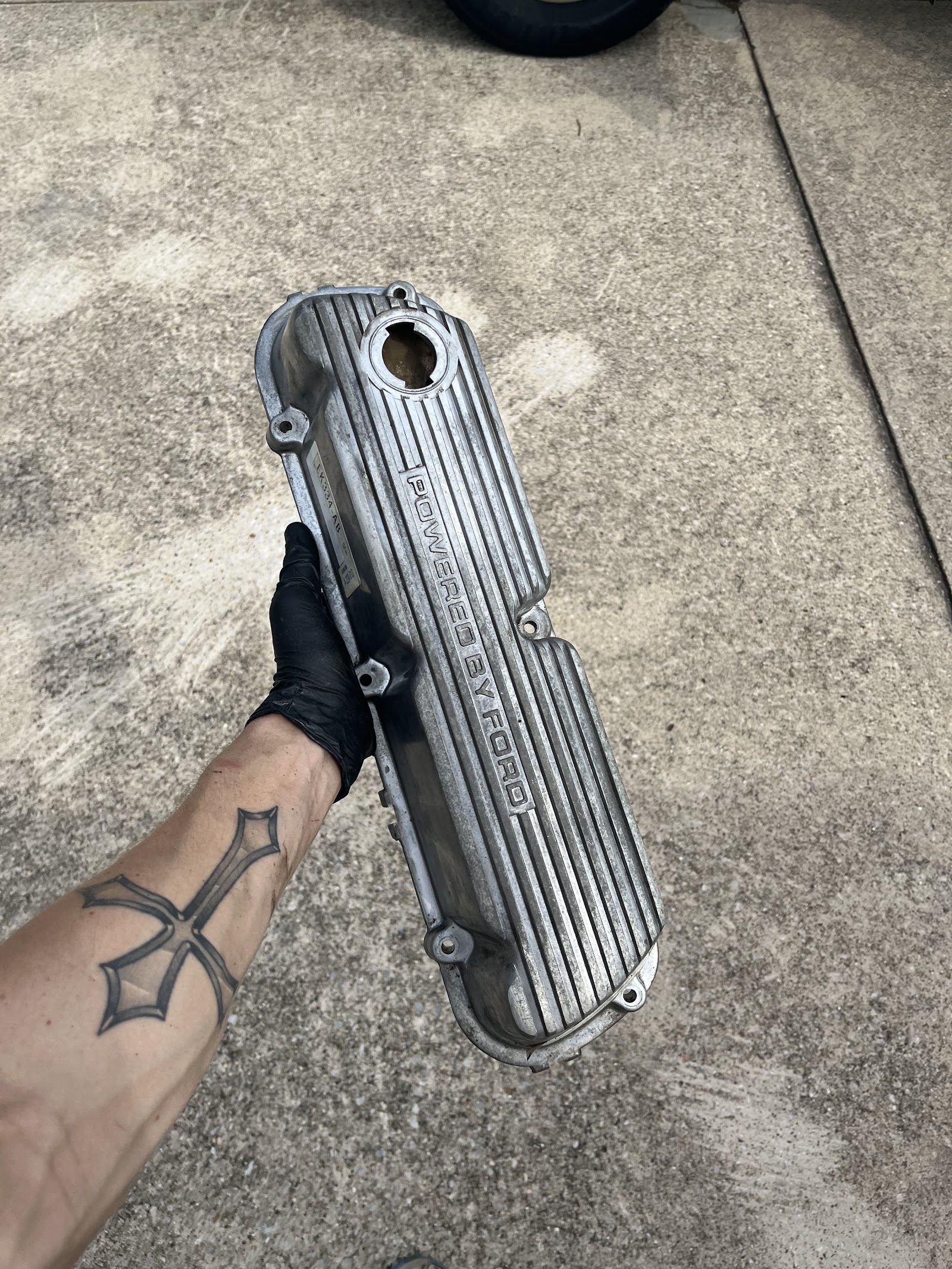 Mechanic holding a Powered by Ford aluminum valve cover
