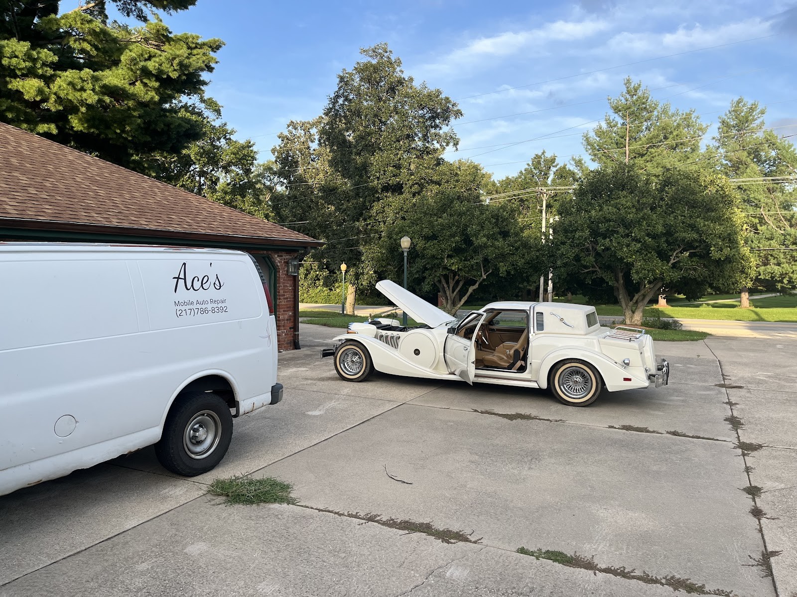 Ace's Mobile Auto Repair van parked beside a classic Zimmer-style neoclassic car in a driveway